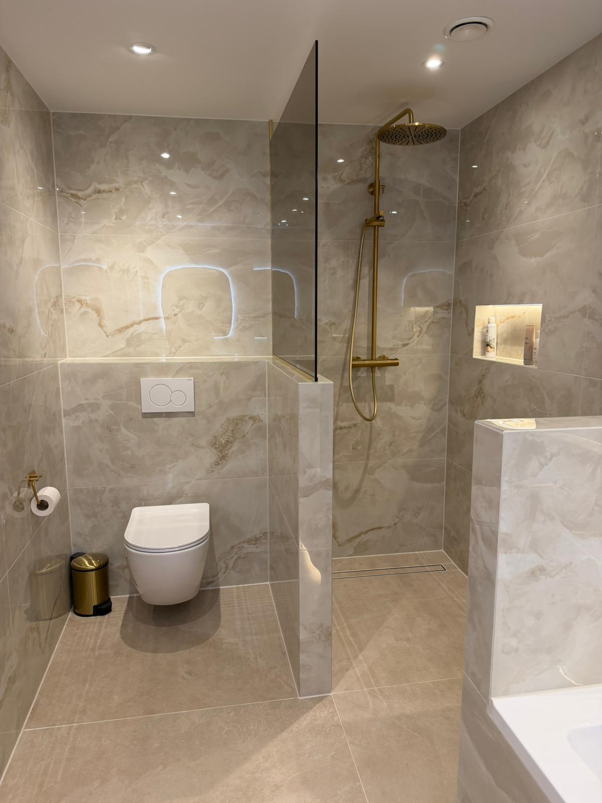 Luxe badkamer met marmertegels en gouden kranen